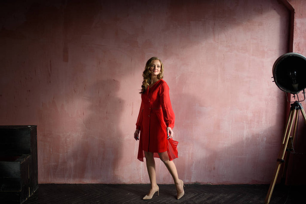 Punainen mekko typy nauraa vastaan punainen seinä
 - Valokuva, kuva