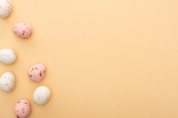 Top view of colorful quail eggs on beige background - Zdjęcie, obraz