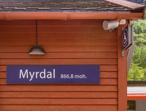 En un edificio de madera roja hay una inscripción con el nombre de la estación y la altura sobre el nivel del mar. MYRDAL STATION, Noruega
. - Foto, imagen