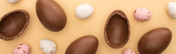 Panoramic shot of quail and chocolate eggs on beige background - Photo, Image