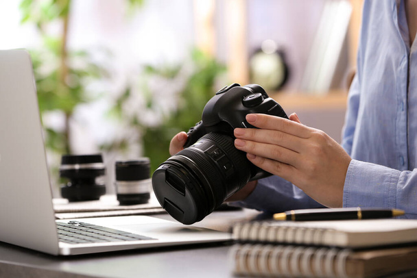 Journalist with camera working at table, closeup - Zdjęcie, obraz