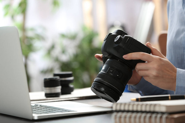 Journalist with camera working at table, closeup - Zdjęcie, obraz