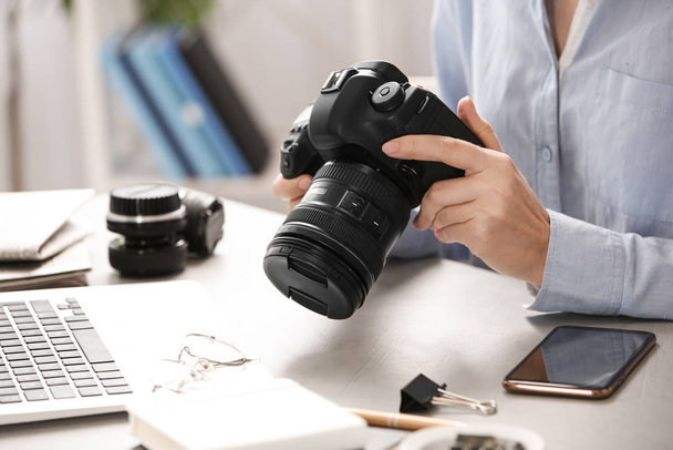 Journalist with camera working at table, closeup - Photo, image