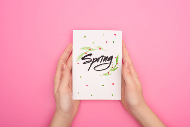 Vista recortada de la tarjeta con letras de primavera en las manos de la mujer en rosa
  - Foto, imagen