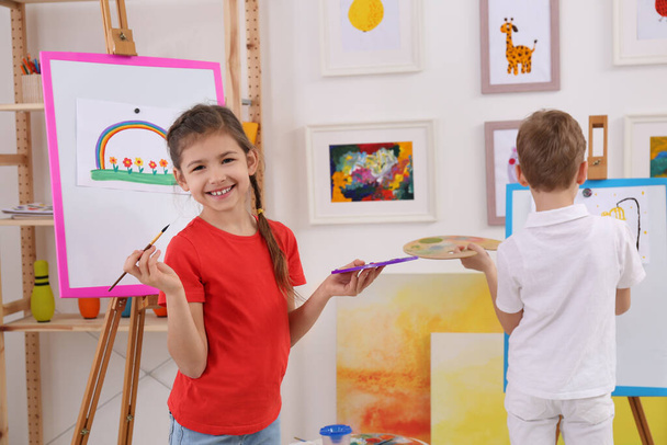 Cute little children painting during lesson in room - Foto, imagen