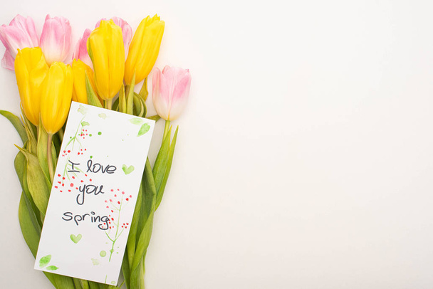 Top view of card with I love you spring lettering on bouquet of tulips on white background - Photo, Image