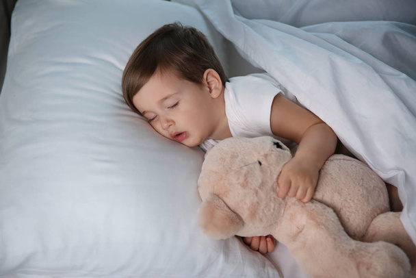 Cute little baby sleeping with toy at home. Bedtime - 写真・画像