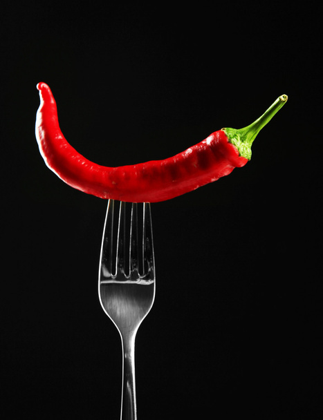 Red hot chili pepper on fork, isolated on black - Foto, Imagen