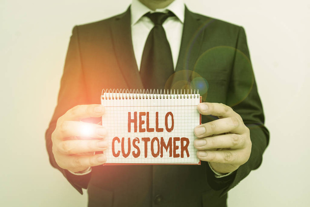 Text sign showing Hello Customer. Conceptual photo greeting used to someone who buys goods or services Male human wear formal work suit office look hold mathematics book use hand. - Foto, Bild