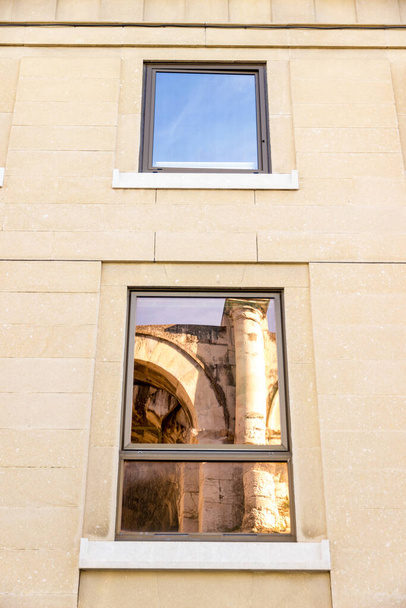 A arena de Nimes, França, refletiu sobre algumas janelas modernas reflexivas nas proximidades
 - Foto, Imagem