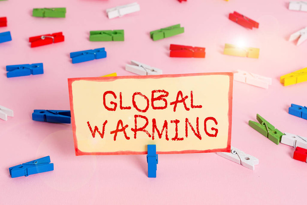 Handwriting text Global Warming. Concept meaning gradual increase in the temperature of the earth s is atmosphere Colored clothespin papers empty reminder pink floor background office pin. - Foto, afbeelding