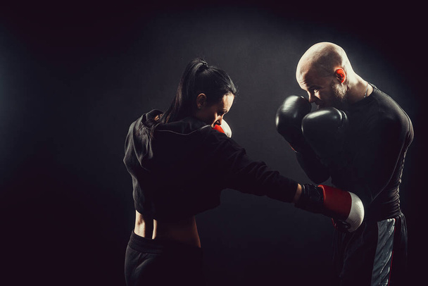 Woman exercising with trainer at boxing and self defense lesson - Foto, Imagem