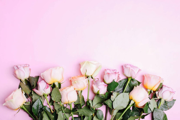 Um buquê de rosas de chá híbridas e floribunda em um fundo rosa
. - Foto, Imagem