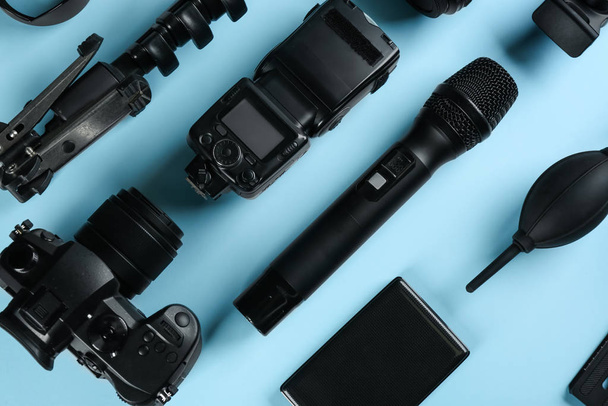 Flat lay composition with camera and video production equipment on light blue background - Fotografie, Obrázek