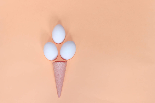 Horizontální obraz bílých vajec a oplatky kužele na růžovém pozadí. Abstraktní pozadí potravin. - Fotografie, Obrázek