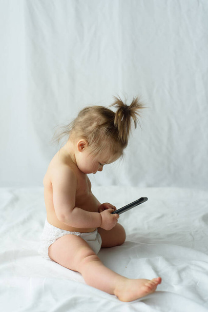 Mignon petit bébé parle sur téléphone portable, isolé sur blanc
 - Photo, image