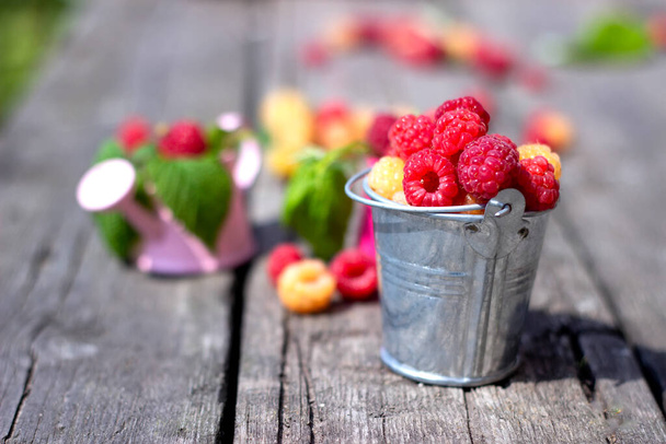 Ripe sweet raspberries on the wooden table in summer time - Φωτογραφία, εικόνα
