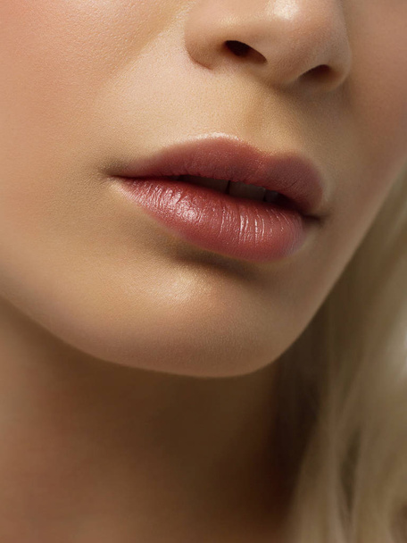 Sexual full lips. Natural gloss of lips and woman's skin. The mouth is closed. Increase in lips, cosmetology. Pink lips and long neck. Gentle pure skin and wavy blonde hair. - Фото, изображение