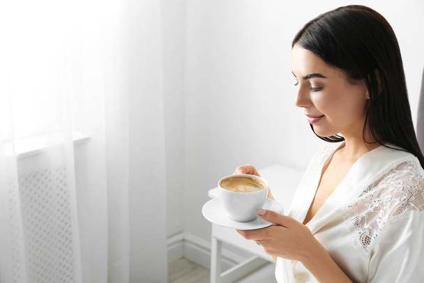 Woman with cup of coffee in bedroom. Lazy morning - Foto, Imagem