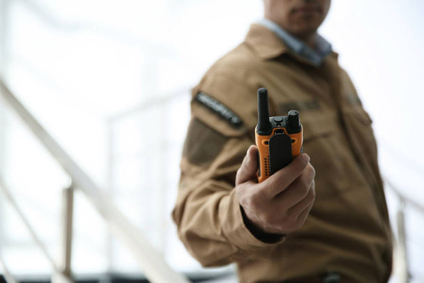 Professional security guard with portable radio set indoors, closeup - Foto, imagen