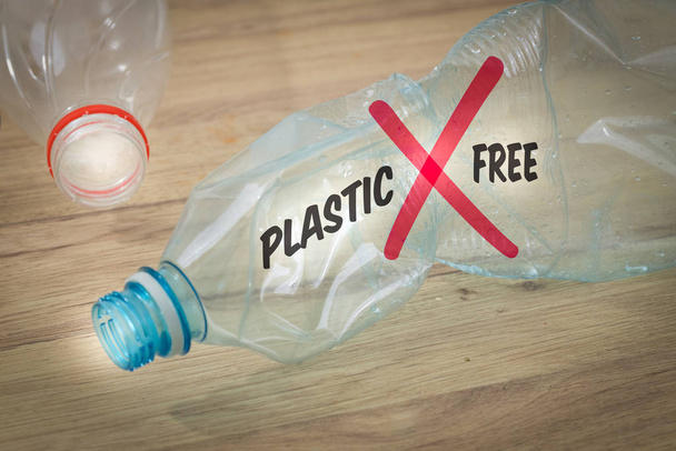 zerkleinerte Plastikflasche mit der Aufschrift "Plastic Free" Das Konzept der bewussten Beschränkung der Produktion und Verwendung von Kunststoffverpackungen - Foto, Bild