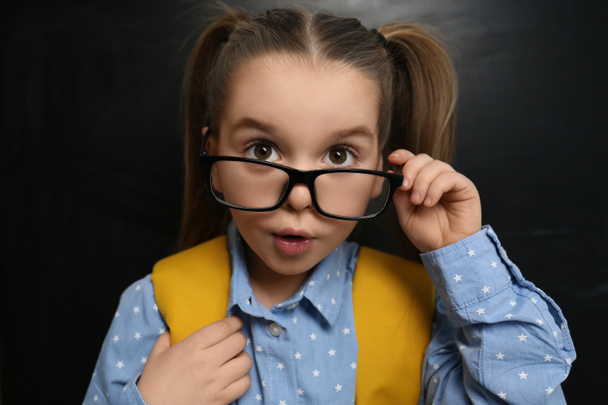 Cute child wearing glasses near chalkboard, closeup. First time at school - Foto, Imagen