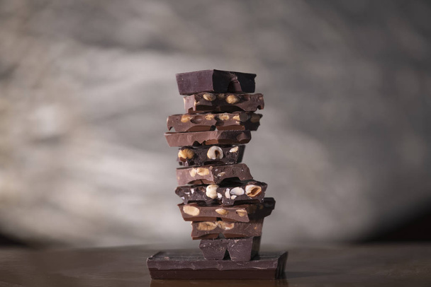 Tornyot alkotó csokoládédarabok diófélékkel - Fotó, kép