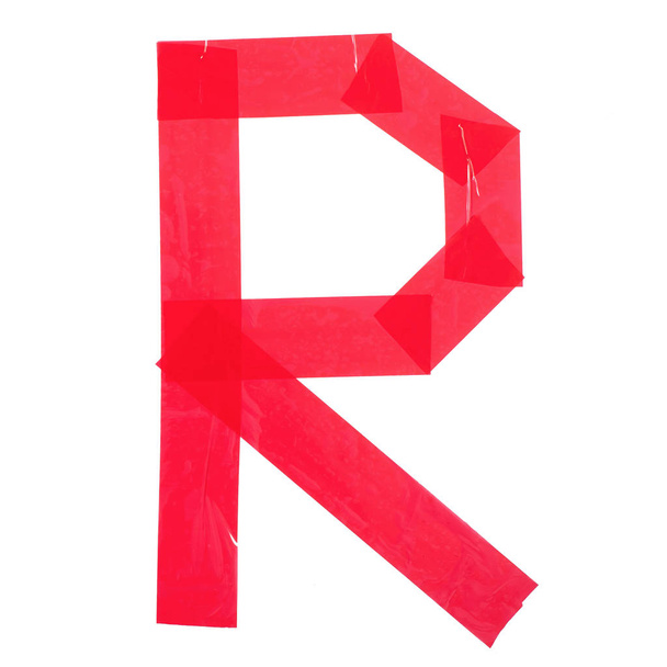 Letter "R" made from red construction adhesive tape. Isolated on white background - Photo, Image