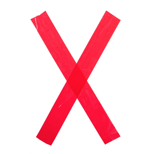 Litera "X" wykonana z czerwonej taśmy klejącej. Izolacja na białym tle - Zdjęcie, obraz