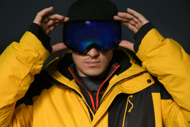 Man wearing stylish winter sport clothes on black background - Foto, Bild