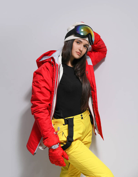 Woman wearing stylish winter sport clothes on light grey background - Foto, Bild