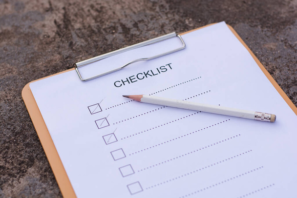 Checklisten-Konzept - Checkliste, Papier und Stift mit Checklisten-Wort auf Holztisch - Foto, Bild
