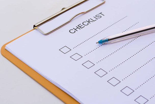 Checklist concept - checklist, paper and a pen with checklist word on wooden table - Foto, Bild