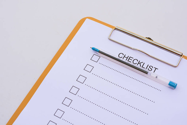 Checklist concept - checklist, paper and a pen with checklist word on wooden table - Фото, изображение