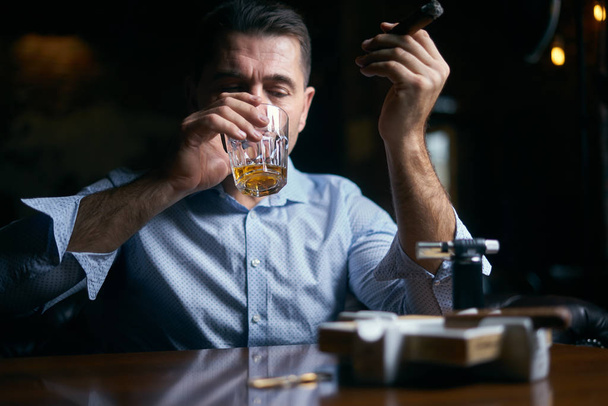 портрет человека, курящего сигару в лаундж-баре
 - Фото, изображение