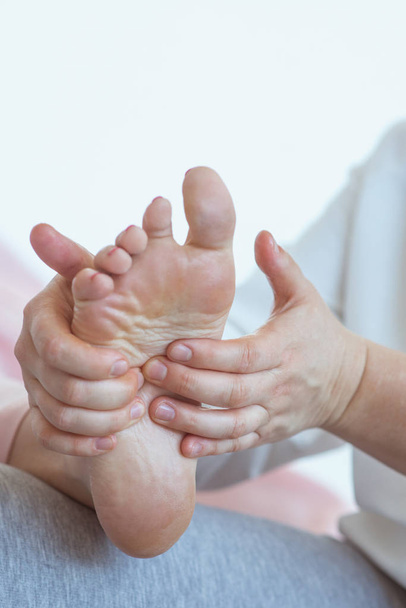 Hand making thai feet massage. Alternative medicine, relax, wellness and thai massage concept  - Foto, afbeelding