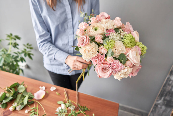 Woman florist creating beautiful bouquet in flower shop. Work in flower shop. Flowers delivery. - Photo, Image