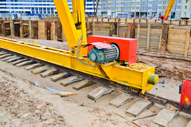Large iron metal yellow supports on rails with wheels with an induction motor of a large construction stationary industrial powerful gantry crane of a bridge type - Photo, Image