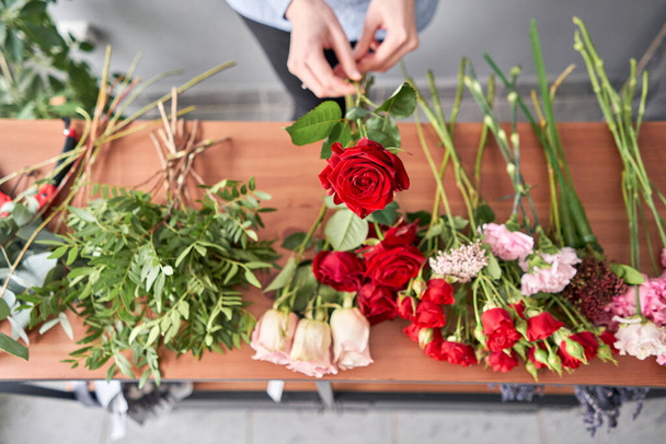 Floral shop concept . Florist woman creates flower arrangement. Beautiful bouquet of mixed flowers. Handsome fresh bunch. Flowers delivery - Фото, изображение