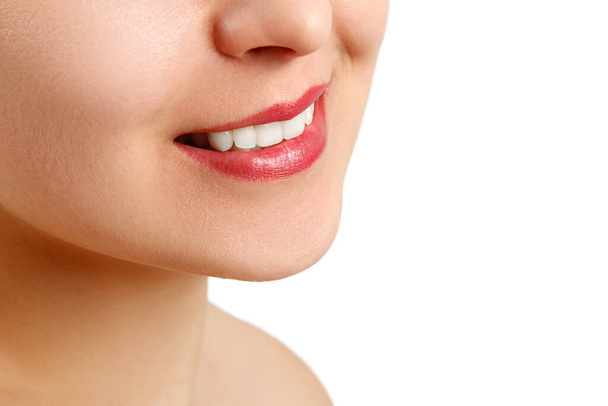 egy fiatal nő mosolya, tökéletes fehér fogakkal. közelkép elszigetelt fehér háttérrel. fénymásolási hely - Fotó, kép