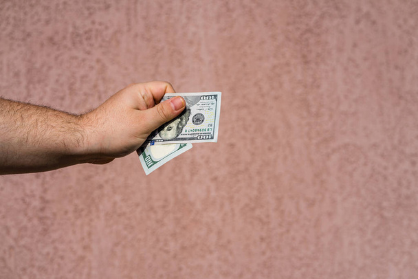 Ręczne trzymanie pokazywanych dolarów i dawanie lub otrzymywanie pieniędzy jak napiwki, pensja. 100 USD banknoty, dolary amerykańskie waluta izolowana z miejsca na ksero. - Zdjęcie, obraz