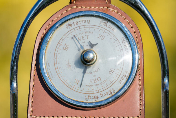 Close-up van een antieke barometer gemaakt van een oude paardenstijgbeugel die de hoge druk aangeeft - Foto, afbeelding
