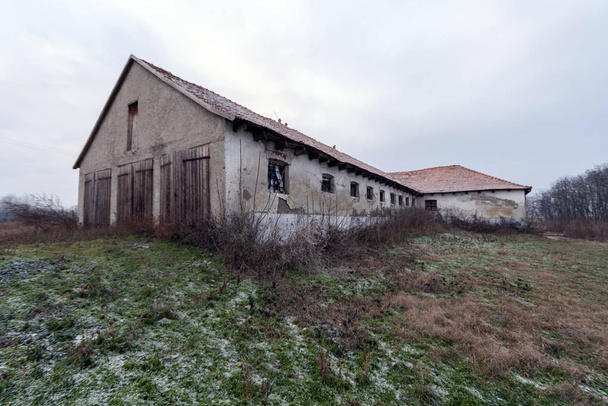 Verlaten gebouw op het hongerige platteland op een winterdag. - Foto, afbeelding