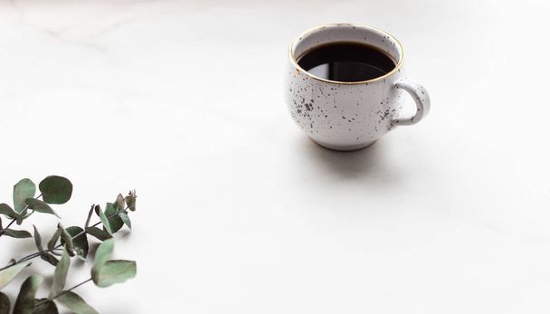 Καφές με κλαδιά ευκαλύπτου σε μαρμάρινο τραπέζι με co - Φωτογραφία, εικόνα