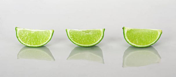 fatia de limão isolada sobre um fundo branco com reflexão
 - Foto, Imagem