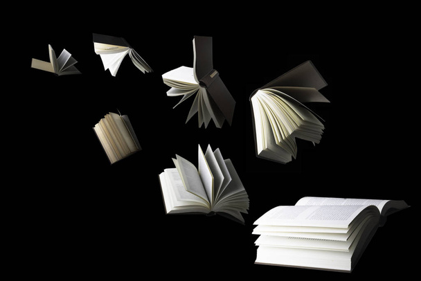 Flying books isolated on black - Фото, изображение