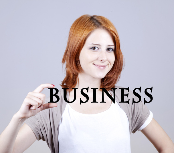 Рудоволоса бізнес-леді показують абстрактне слово "бізнес"
. - Фото, зображення