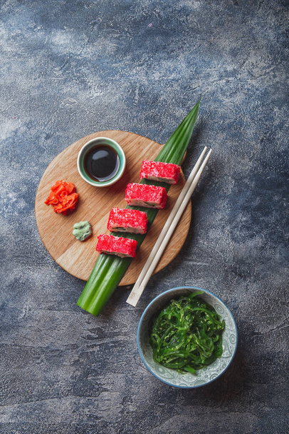 Sushi rolls on wooden board. Stone background. Top view. - Fotografie, Obrázek