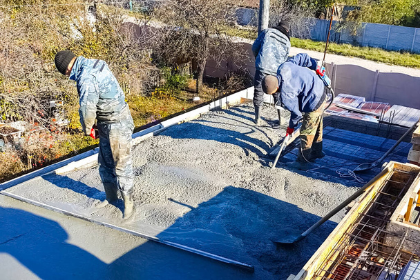 Москва, Россия - 12 ноября 2019 года: межэтажное перекрытие из бетона. Рабочие на стройке. Пустые полы
. - Фото, изображение