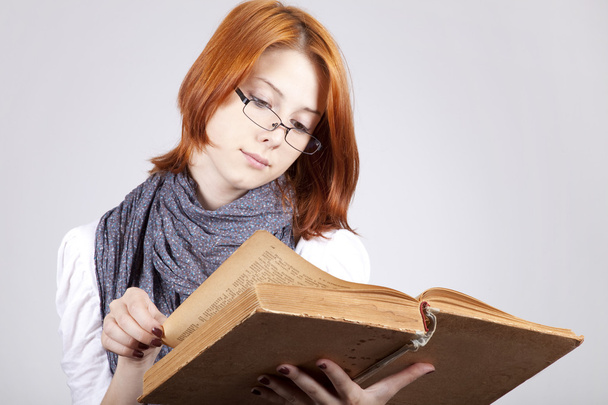 Young doubting fashion girl in glasses with old book - Photo, image